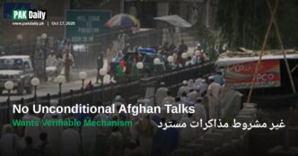 Crowds cross the Pakistan-Afghanistan border at Torkham, beneath signage reading Welcome to Pakistan